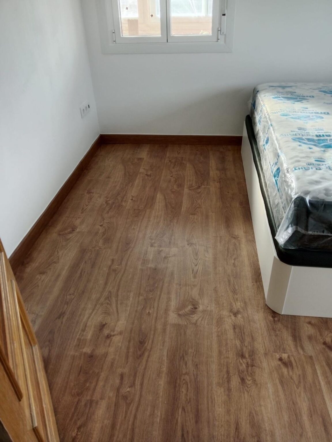 Dormitorio tras reforma integral con suelo renovado y mejoras funcionales realizadas por Reformas Noriega